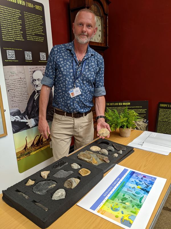 Photo of a museum staff member demonstrating fossils in a handling session.